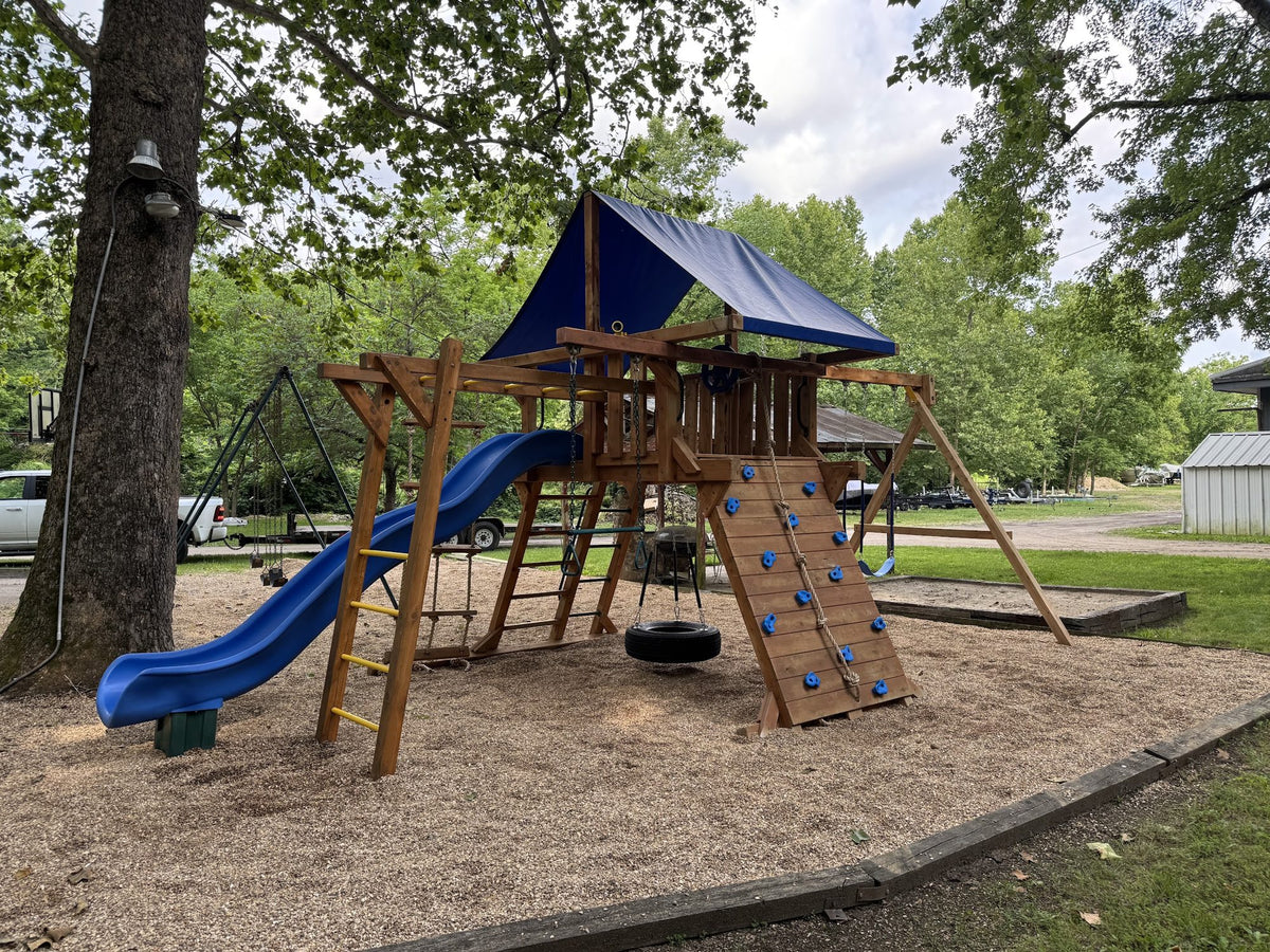 Ozark cedar playset with blue roof in a backyard