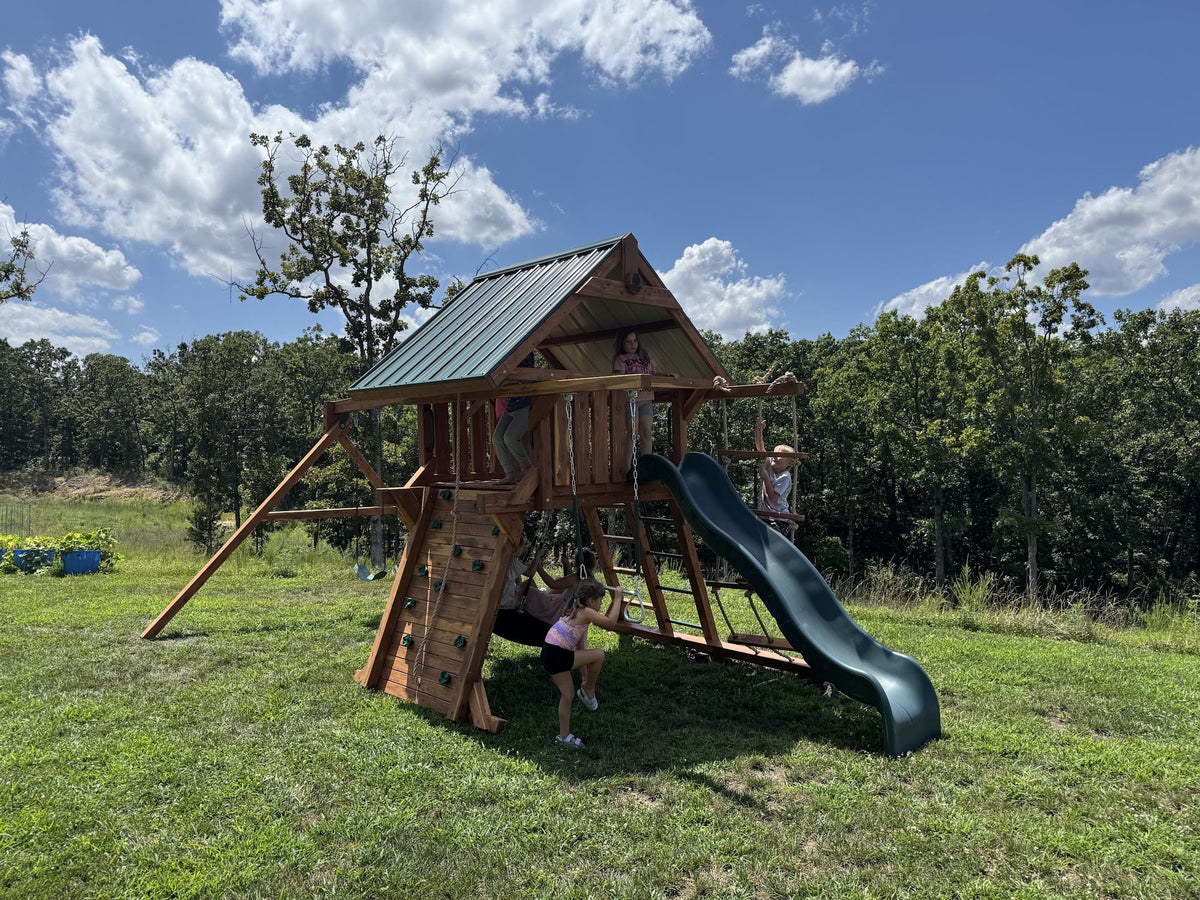 Ozark cedar playset with green slide under a blue sky