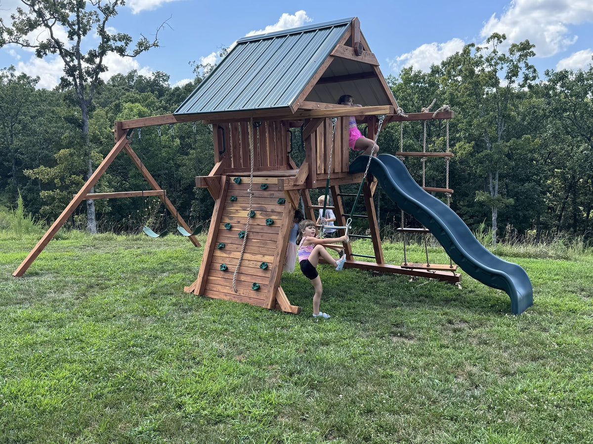 Ozark playset with green metal roof and rock wall